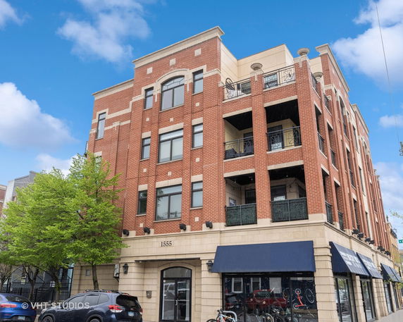 Front view of a multi-story brick building with balconies.