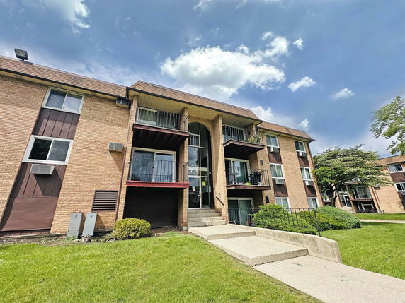 Front view of a multi-story apartment building with balconies.