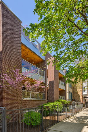 Front view of a modern multi-story brick building with balconies.