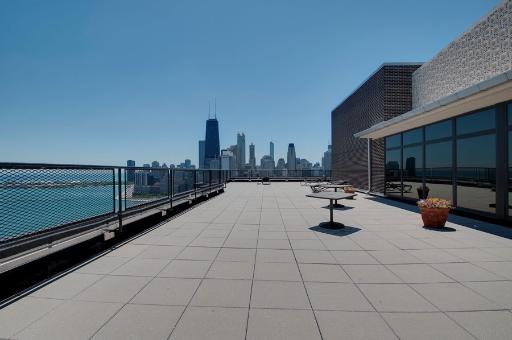 Rooftop terrace with a view of a city skyline.