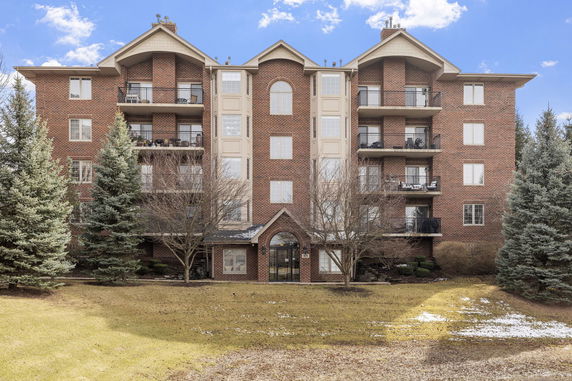 Front view of a multi-story brick apartment building with balconies.