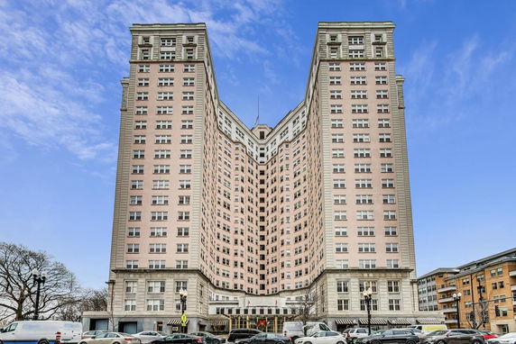 Front view of a tall, multi-story building with an angled structure and multiple windows.