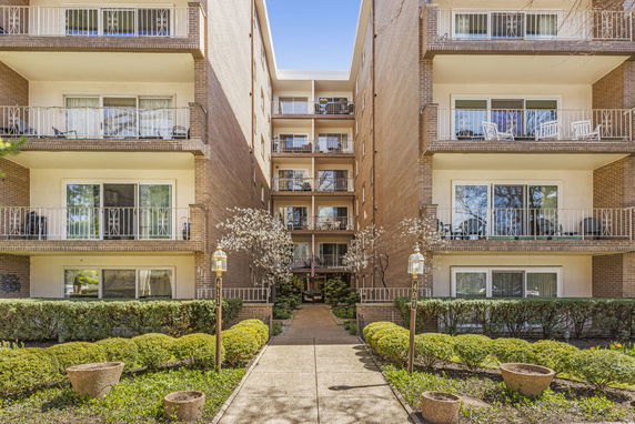 Front view of a multi-story apartment building with balconies.