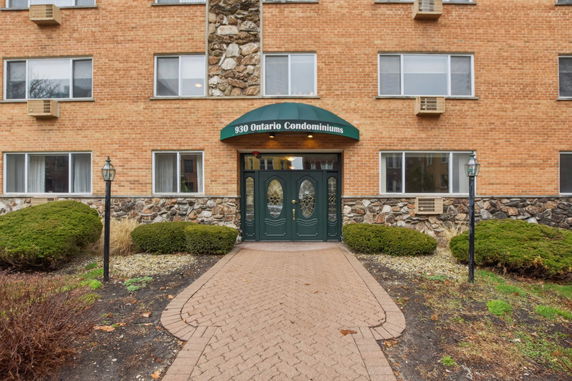 Front view of a condominium building with a green canopy entrance.