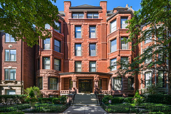 Front view of a brick townhouse with bay windows and detailed stonework.