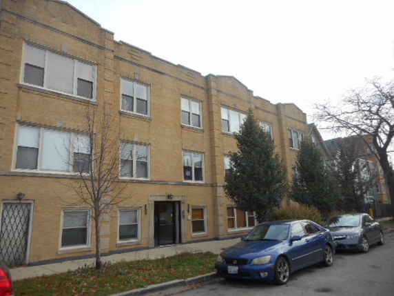Front view of a three-story apartment building with a brick exterior.