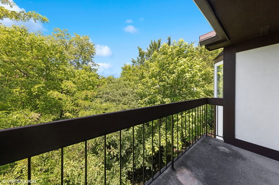 View of surrounding green trees from a balcony.