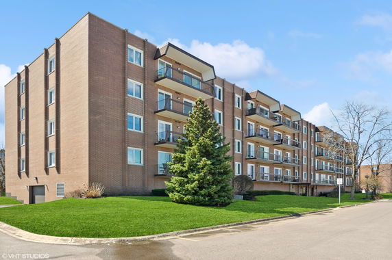 Front view of a multi-story apartment building with balconies.