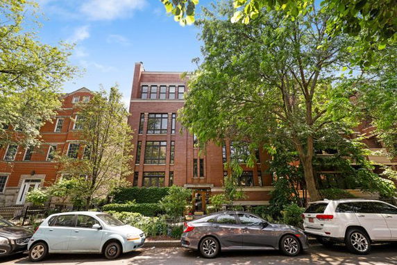 Front view of a multi-story brick building with large windows.