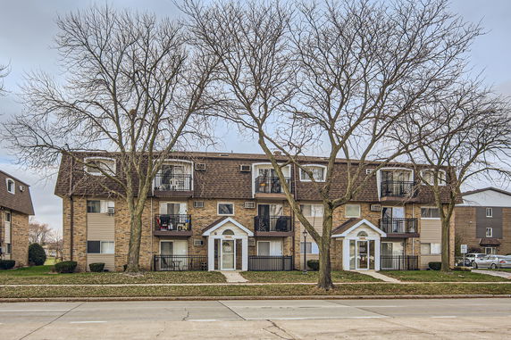 Front view of a multi-story residential building with balconies.