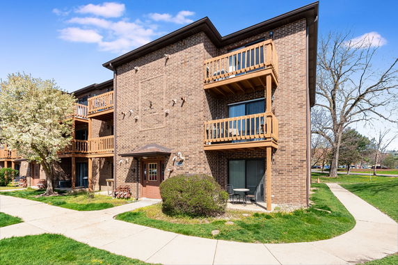 Front view of a multi-story brick building with balconies.