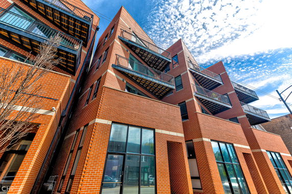 Front view of a multi-story brick building with multiple balconies.