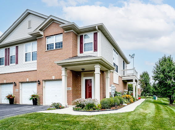 Front view of a multi-story house with a brick exterior and attached garage.