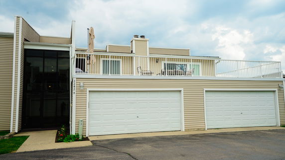 Front view of a house with an upper deck and double garage.