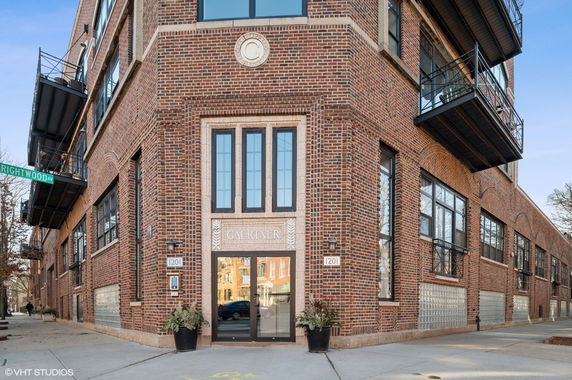 Front view of a multi-story brick building with large windows and metal balconies.