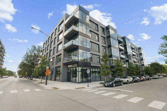 Front view of a modern multi-story apartment building with balconies.