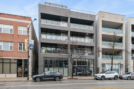Front view of a multi-story building with glass balconies.