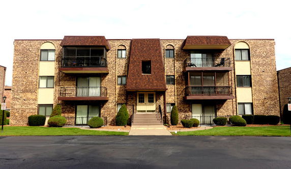 Front view of a multi-story apartment building with balconies.