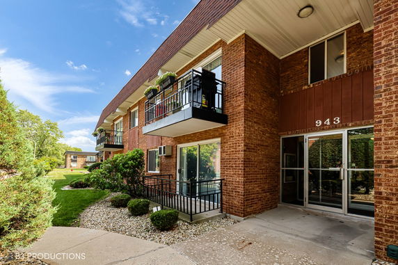 Front view of a brick apartment building with balconies.