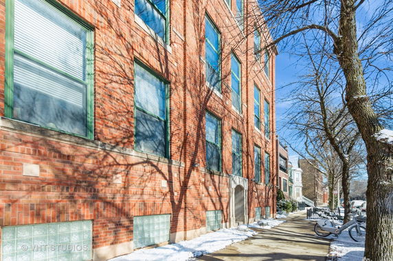 Front view of a multi-story brick building with multiple windows.