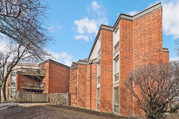 Front view of a multi-story brick building with balconies.