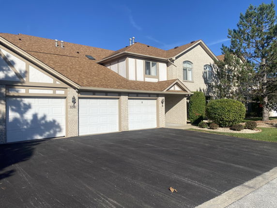 Front view of a two-story townhouse with three garages.