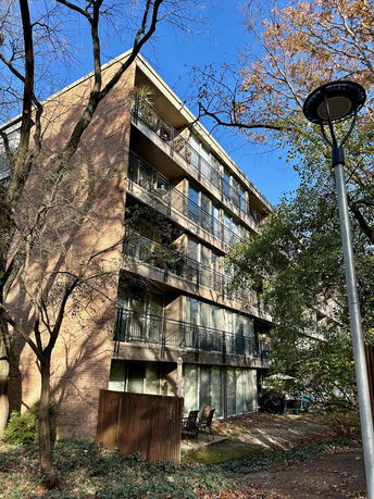 Front view of a multi-story apartment building with balconies.