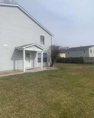 Front view of a two-story house with siding and covered entrance.