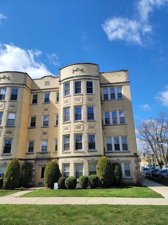 Front view of a multi-story apartment building with decorative architectural features.
