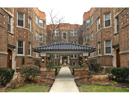 Front view of a multi-story brick apartment building with a covered walkway entrance.