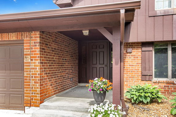 Front view of a house with a covered entrance and brick facade.