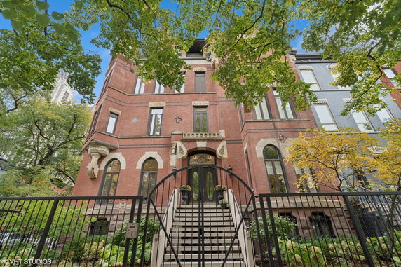 Front view of a multi-story brick building with a staircase entrance and decorative details.