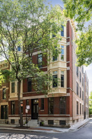 Front view of a multi-story brick building on a street corner.