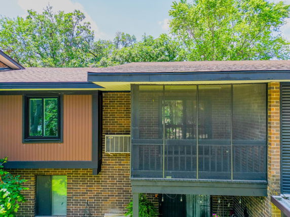 Front view of a house with brick exterior and screened porch.