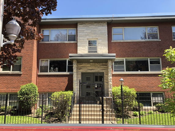 Front view of a two-story brick building with multiple windows and a central entrance.