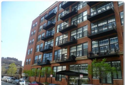 Front view of a multi-story apartment building with balconies.