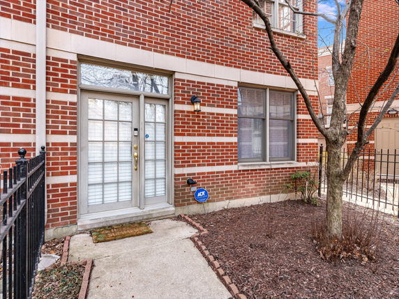 Front view of a brick house with a glass door entrance.
