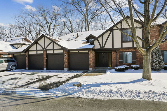 Front view of a two-story house with multiple garages and snow-covered roof.