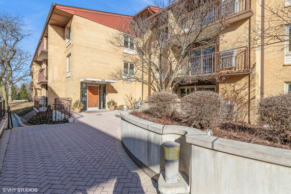 Front view of a multi-story apartment building with balconies and main entrance.