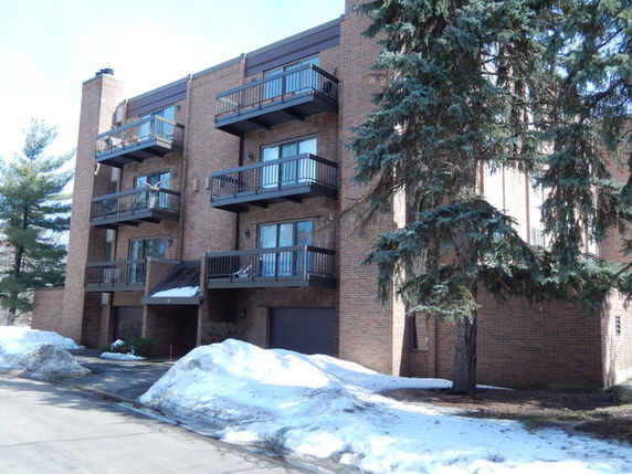 Front view of a multi-story brick apartment building with balconies.