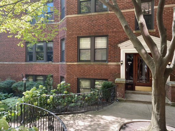 Front view of a brick residential building with multiple windows and a main entrance.