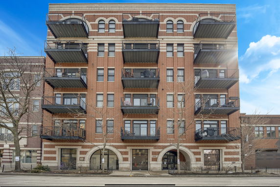 Front view of a multi-story brick building with balconies.