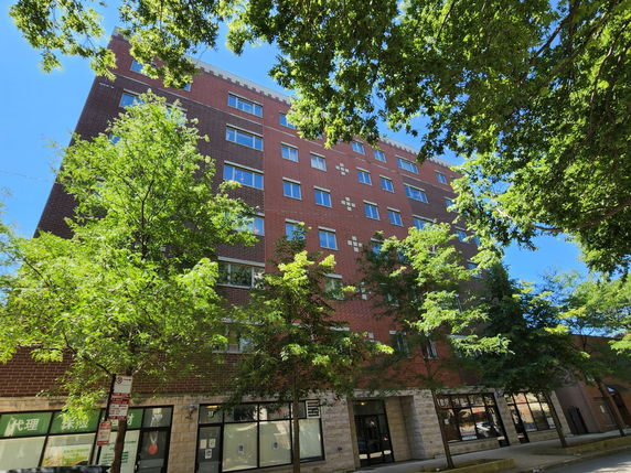 Front view of a multi-story brick building with numerous windows.