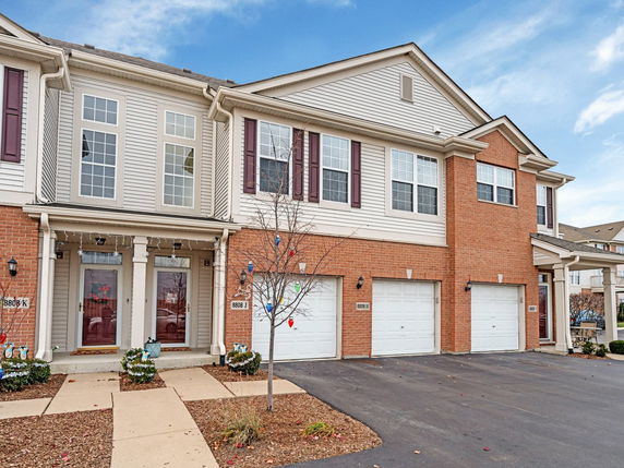 Front view of a two-story townhouse with attached garages.