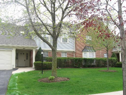 Front view of a two-story house with garage and brick facade.