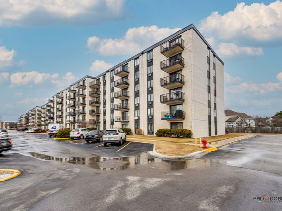 Front view of a multi-story apartment building with balconies.