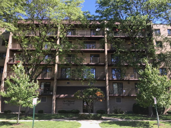 Front view of a multi-story condominium building with balconies.