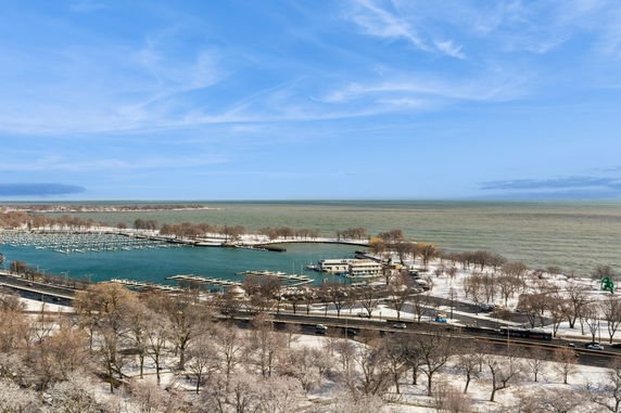 Panoramic view of a marina and surrounding area with snow-covered trees and roads.