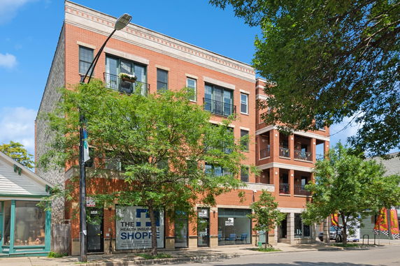 Front view of a multi-story brick building with balconies.