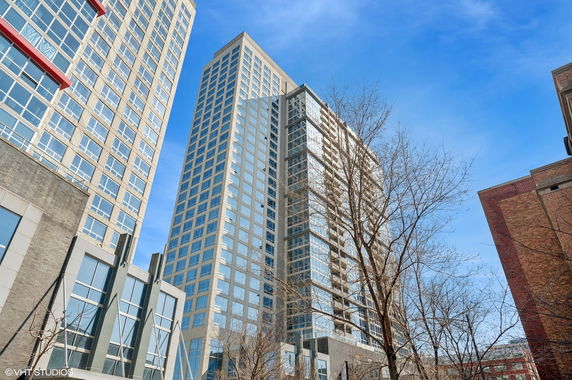 View of a tall multi-story modern building with numerous windows.